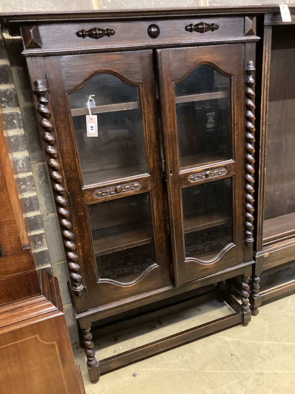 A 1920s oak two door glazed bookcase, width 92cm depth 30cm height 140cm